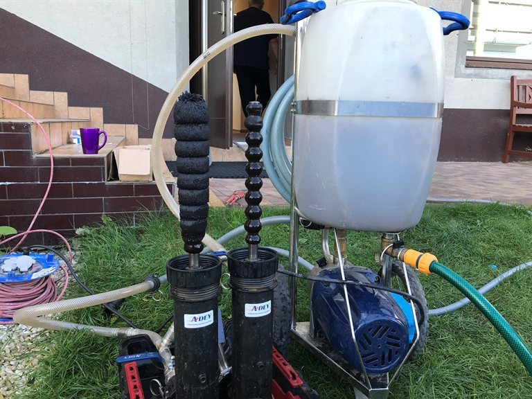 Filtry magnetyczne ADEY wyciągnięte z obudów po czyszczeniu — pokryte czarnym magnetytem z instalacji CO